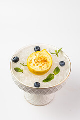  lemon passet served in bowl with crushed ice with fresh blueberries on a white background,