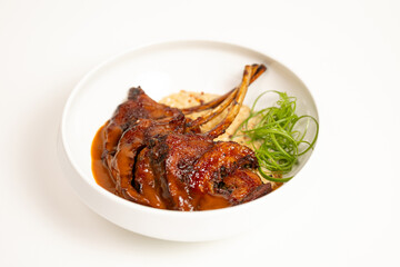 Grilled lamb chops with sauce on white background