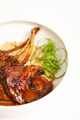 Grilled lamb chops with sauce on white background
