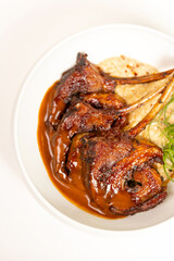 Top view close-up of grilled lamb ribs with sauce and garnish