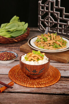 Stir-fried pork with peppers and chili over rice in wooden bowl - Asian cuisine on rustic wooden table