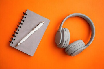 Gray notebook white pen gray headphones image