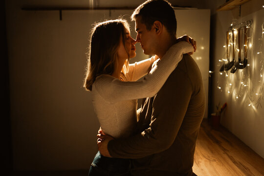 Young kissing passionate couple having a romantic date at home celebrating Valentine's Day