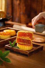Traditional Chinese Mooncakes with Lotus Seed Paste on Wooden Base with Tea Service