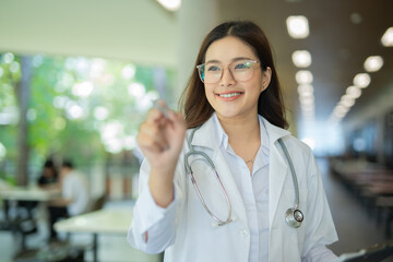 Fototapeta premium Female doctor in white coat holding hands with medical and healthcare icons. 