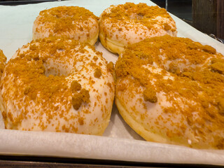 White Glazed Donuts with Crumbled Cookie Topping on Bakery Display