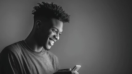 Black and white portrait of a young man smiling while looking at his phone, modern lifestyle. - Powered by Adobe