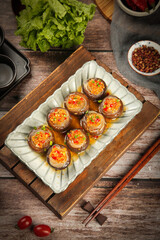 Stuffed Shiitake Mushrooms with Vermicelli Noodles Asian Teppanyaki Signature Dish on Wooden Board