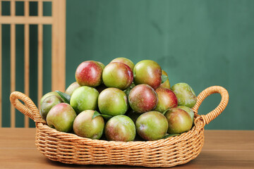 Fresh Green and Red Plums in Wicker Basket - Organic Summer Fruit Display