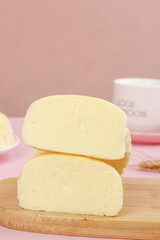 Homemade Fluffy Steamed Cake Slices on Wooden Board with Pink Background