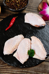 Raw Chicken Wings and Meat Portions on Slate Board with Spices for Gourmet Cooking