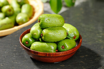 Fresh Mini Kiwi Fruits in Wooden Bowl - Healthy Green Superfood on Dark Background