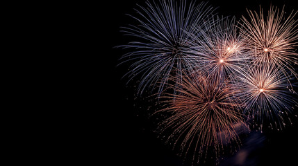 Colorful fireworks exploding in night sky with dark background