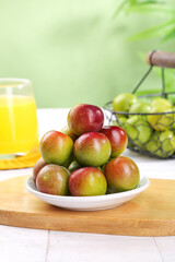 Fresh Ripe Plums on Plate with Orange Juice and Fruits on Wooden Cutting Board