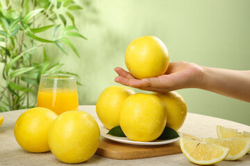 Fresh Fujian Pomelo Citrus Fruits with Orange Juice on Wooden Table - Healthy Asian Citrus Display