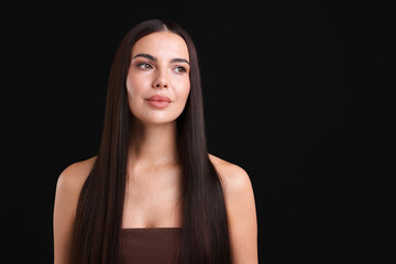 Woman with beautiful smooth hair after lamination procedure on black background, space for text