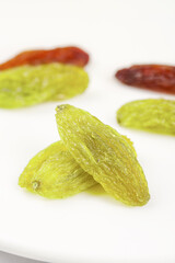 Green and Red Xinjiang Raisins on White Background - Mixed Dried Grapes Varieties