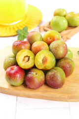 Fresh Szechuan Plums Cut Into Pieces on Wooden Base Cutting Board Red Green Stone Fruit