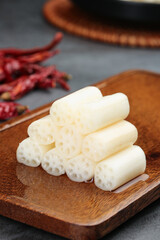 Pickled lotus root slices with spicy chili peppers on wooden board - Asian cuisine ingredients
