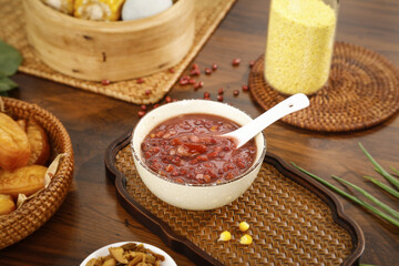 Red bean porridge in bowl with spoon on bamboo placemat with traditional Asian breakfast setting