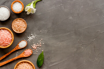 Obraz na płótnie Canvas Beauty spa therapy cosmetics and wellness flat lay - sea salt in many bowls with flowers, top view
