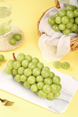 Fresh Green Grapes Display on Marble Board and Wicker Basket Yellow Background Seasonal Fruit Photography