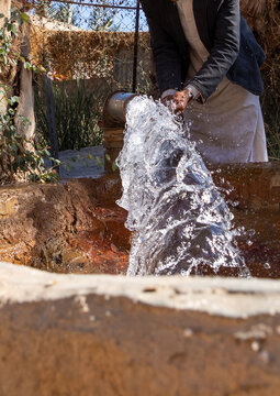 Thirsty saudi man drinking water in a farm well, Najran Province, Najran, Saudi Arabia