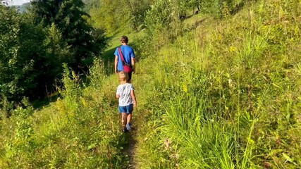 Father and son walking together on a forest path