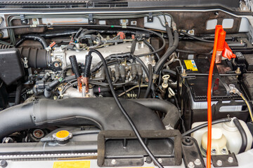 救援される側の車のエンジンルームに繋がれた部スターケーブル