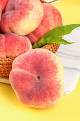 Fresh Red Fuzzy Peaches in Wicker Basket on Yellow Background - Organic Summer Stone Fruit