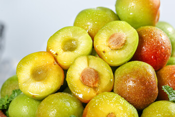 Fresh Cut Plums with Water Droplets Showing Yellow Pulp and Pits - Juicy Stone Fruit Pieces