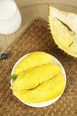 Fresh Golden Durian Fruit Flesh on Plate with Traditional Bamboo Mat - Thailand's Exotic Tropical Fruit