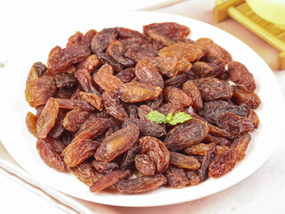 Red Raisins on White Plate with Fresh Mint Garnish - Healthy Dried Fruit Snack