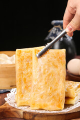 Hand Grating Fresh Aged Cheese with Metal Grater on Wooden Board for Cooking Preparation