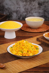 Turmeric rice dish with fresh herbs on wooden board in rustic kitchen setting