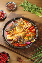 Spicy Fish Head with Chopped Peppers and Fresh Herbs in Traditional Red Sauce