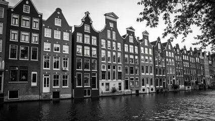 Naklejka premium Charming canal houses reflect in water, showcasing unique architecture and historical beauty in serene black and white setting