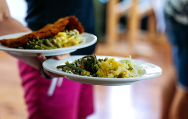 Two plates of delicious food with vegetables and meats in restaurant setting