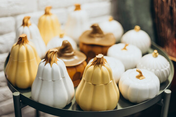 Handmade ceramic pumpkin candles in a cozy craft market.