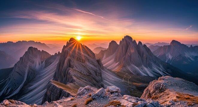 Sunrise over majestic mountain peaks with a clear sky and vibrant colors.