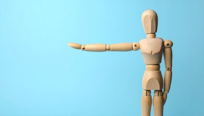 A light-brown wooden mannequin figure extends its arm, gesturing to the right against a bright, light-blue backdrop.