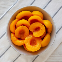 Healthy Organic Canned Peach Halves in a Bowl, top view.