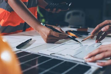 Closeup of team of industrial engineers meeting analyze machinery blueprints consult project on table in manufacturing factory. Working in manufacturing plant or production plant.