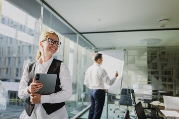 Business professionals engage in a dynamic meeting in a modern office setting with presentation materials and collaborative atmosphere