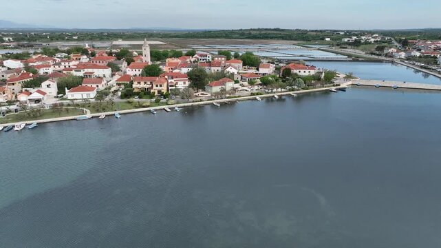 Historic coastal town Nin captured by drone in spring. Old town Nin with stone houses and Adriatic backdrop filmed from above, showing heritage and coastal charm in springtime Croatia