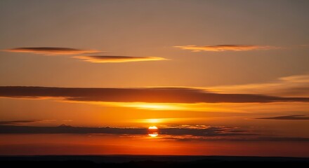 Obraz premium Vibrant Sunset Over Water with Golden Sky and Clouds.
