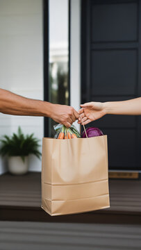 Detalhe de m&atilde;o entregando as compras a cliente no delivery com frutas e legume em casa