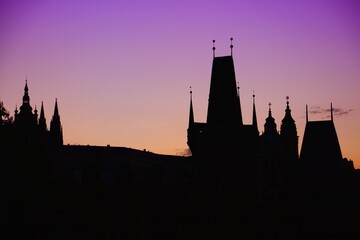 Naklejka premium Towers of Prague, Czech Republic. Black monument silhouette against sunset light.