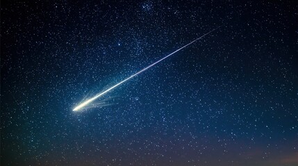 A brilliant meteor streak with a glowing tail in a star-filled night sky.
