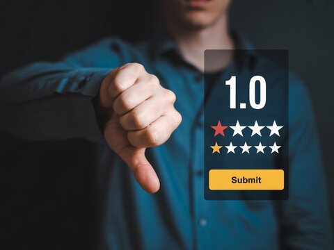 Man gives thumbs down to one star rating showing negative feedback online now - Powered by Adobe
